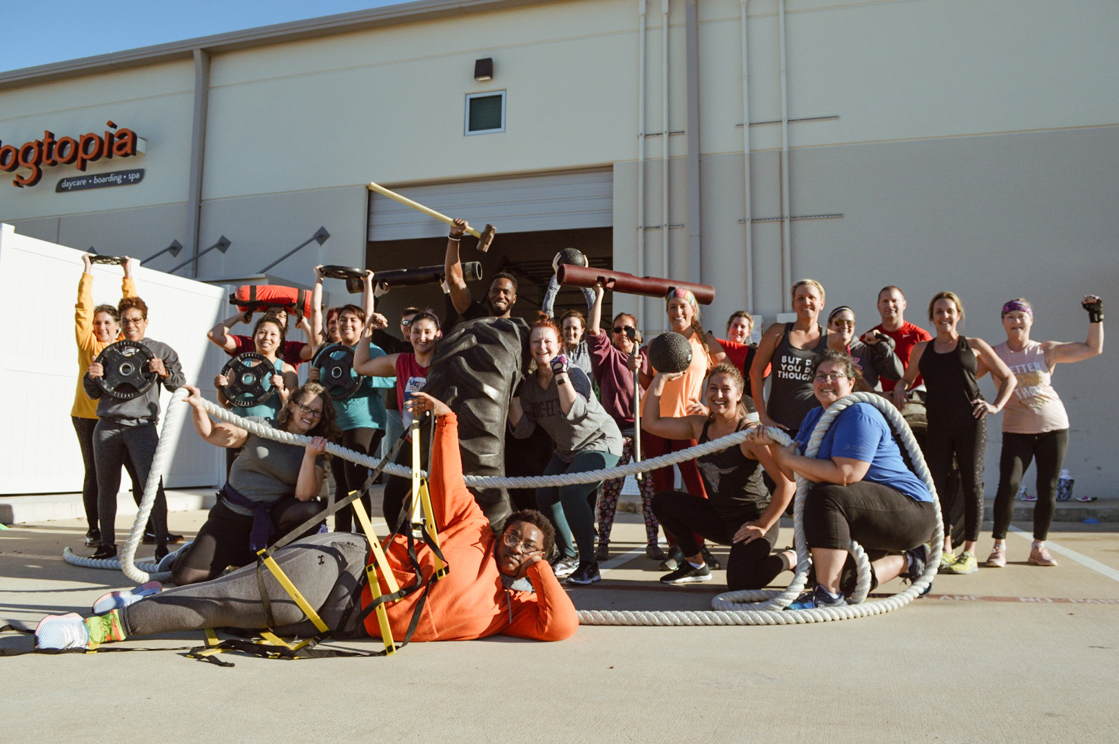 An outdoor functional training class with ropes, plates and sleds